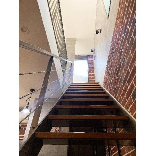 【階段】リビングから２階へとつづくスリップ階段。デザイン性が高く、リビングや玄関ホールの開放感にも一